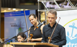 Mit Geige am Rednerpult: Nach musikalischen Klängen durfte anschließend das Publikum noch den Worten eines der Musikanten lauschen (Bild: Sarah Hähnle)