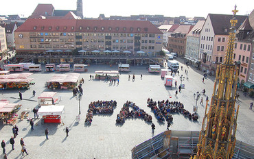 Schülerinnen und Schüler, die an unserer Abschlussaktion bei der Schulmesse Global Learning im Jahr 2015 teilgenommen haben, bildeten das Wort "FAIR" auf dem Nürnberger Hauptmarkt. (Bild: Kerstin Stuebs)