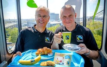 TransFair-Vorstand Dieter Overath und Schauspieler und Fairtrade-Unterstützer Joachim Król genossen mit Blick auf Köln Fairtrade-Frühstück in der Seilbahn.(Bild: Manuel Kniepe) 
