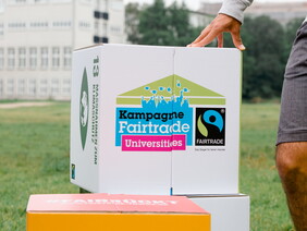 Kreativ, engagiert & fair - jede zehnte Hochschule in Deutschland ist Fairtrade-University. Auf dem Bild zu sehen ist das Logo der Kampagne auf einem großen Sitz-Würfel abgebildet. Foto: Fairtrade/verenafotografiert