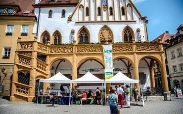 Die Fairtrade-Townn Amberg hängte zur Auszeichnung die Fahne  „Wir sind Fairtrade-Stadt“ medienwirksam vom Balkon des historischen Rathauses. (Bild: Stadt Amberg)